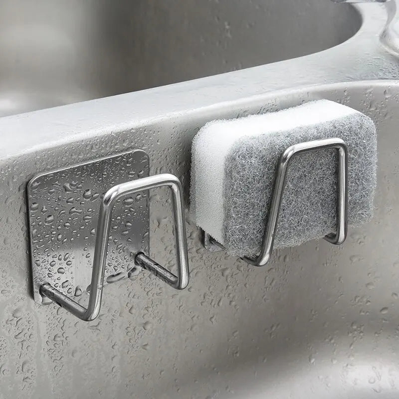 Suporte autoadesivo em aço inox para esponja de pia com sistema de drenagem rápida.